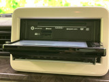 画面を開いて使用するモニターを備え、周辺にはディスクやSDカードの表示があります。映像や音楽などのメディアを活用でき、車内での過ごし方の幅を広げてくれます。