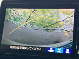 後方の様子と進行方向の目安を画面で確認でき、駐車時の周囲確認をサポートします。画面下には視点を切り替える表示もあり、車庫入れや切り返しに役立ちます。