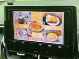 画面には番組映像が表示され、停車中にテレビや映像を視聴して過ごせます。大きく見やすい画面で、休憩時間のひとときにも活用できる、車内での楽しみを広げる装備です。
