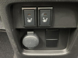 運転席まわりのスイッチ類は左右の座席に対応する表示があり、必要な操作を確認しやすい配置です。足元には電源用の差し込み口も備え、日常の車内利用に便利です。