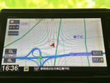 地図上に現在地や周辺道路が表示され、画面上で位置関係を確認できます。縮尺の変更や案内画面への切り替え項目も見やすく配置されており、目的地へ向かう際の確認に便利なナビ画面です。