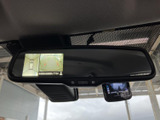 ルームミラー内に後方と車両周辺を確認できる映像表示があり、駐車時の状況把握を助けます。ミラー下部にも画面付き機器を備え、運転中に情報を確認しやすい配置です。