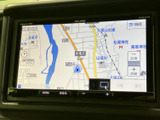 地図上に現在地や周辺の道路が表示され、目的地までのルート確認に役立ちます。縮尺や地図上の情報を見ながら、行き先を設定しやすいナビ画面です。
