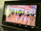 画面にはテレビ番組が表示され、停車中に映像を楽しみたい場面で活用できます。映像が大きく見やすく、画面下には音量やホームなどの操作項目も配置されています。