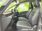 前席まわりは視界が広く、運転席から助手席まで見通しのよい空間です。シートは身体を支える形状で、落ち着いた色合いが室内にまとまりを添えます。足元にもゆとりがあり、乗車中も自然な姿勢で過ごせます。