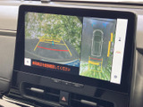 後方の映像に加えて車両周辺を上から捉えた表示もあり、駐車時の位置確認をサポートします。画面のガイド表示を目安に、周囲を確認しながら操作できます。