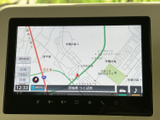 画面には現在地周辺の地図が表示され、道路や施設名を確認できます。タッチ操作部も画面下にまとまっており、移動中に必要な案内を見つけやすい配置です。