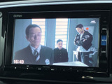 画面にはテレビ番組が表示されており、停車中に映像を楽しめる装備です。時刻も見やすく表示され、目的地への案内画面とは異なる使い方もできます。