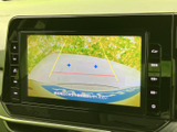 画面には車両後方の映像と目安線が表示され、駐車時に周囲の位置関係を確認するのに役立ちます。画面表示を見ながら、後退時の安全確認をサポートしてくれる装備です。