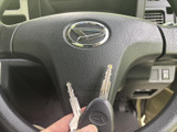 握りやすい形状で、運転中の操作を支えるステアリングです。中央にブランドエンブレムが配され、手元にはキーも確認できます。運転席まわりをシンプルにまとめています。