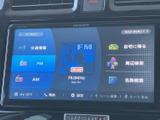 画面にはナビメニューやFM・AMなどの項目が表示され、必要な情報を見つけやすい構成です。目的地検索や周辺検索にも対応した画面で、日々の移動をサポートします。