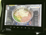 画面には料理番組の映像が表示されており、停車中のひとときにも楽しめます。下部には音量や各種操作のアイコンが並び、画面上で機能を確認しやすい仕様です。