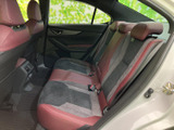 後席には複数人で座れるシートとヘッドレストを備え、赤いアクセントが車内の印象を引き締めます。窓から外の景色を見渡せ、同乗者との移動にも使いやすい空間です。